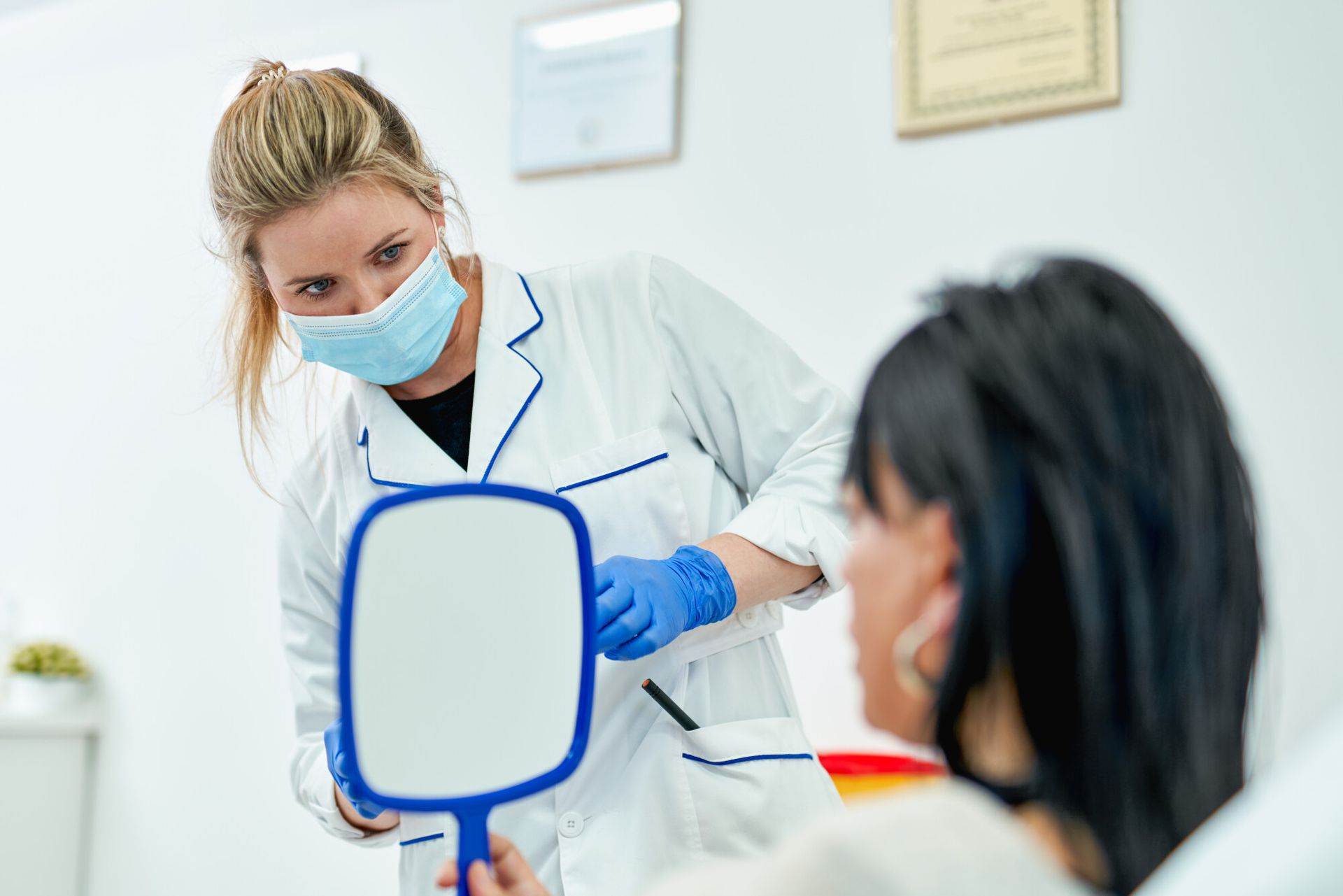 Dentist giving patient a mirror to review smile