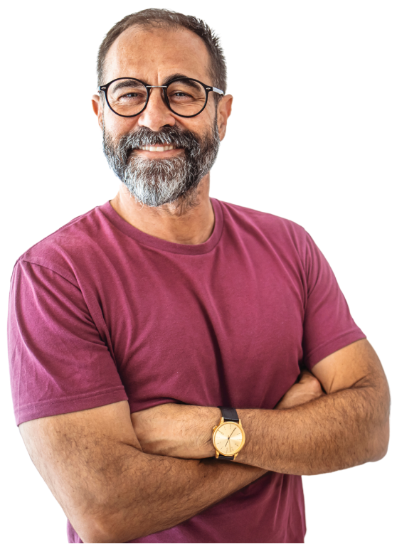 A man with glasses and a beard is standing with his arms crossed and smiling.