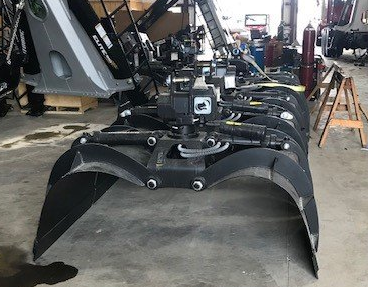 A large metal claw is sitting on the ground in a garage.