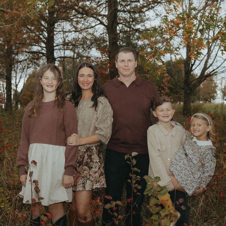 A family is posing for a picture in a field.