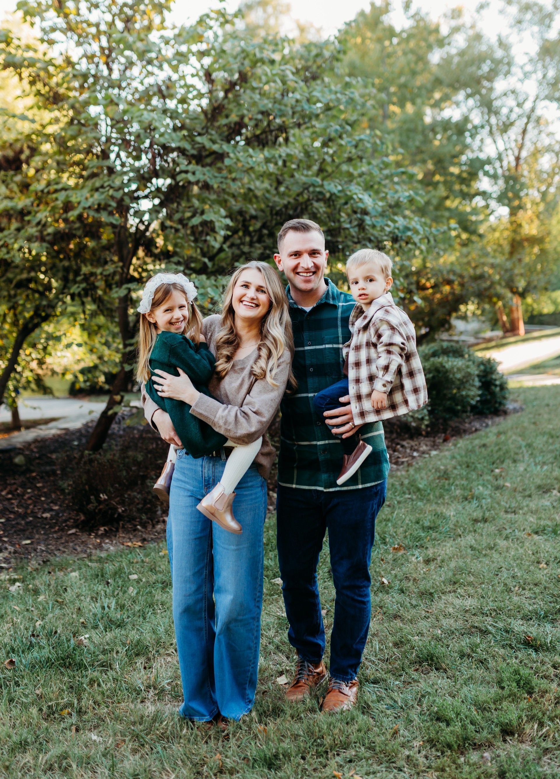 A man and woman are holding a baby and a little girl.