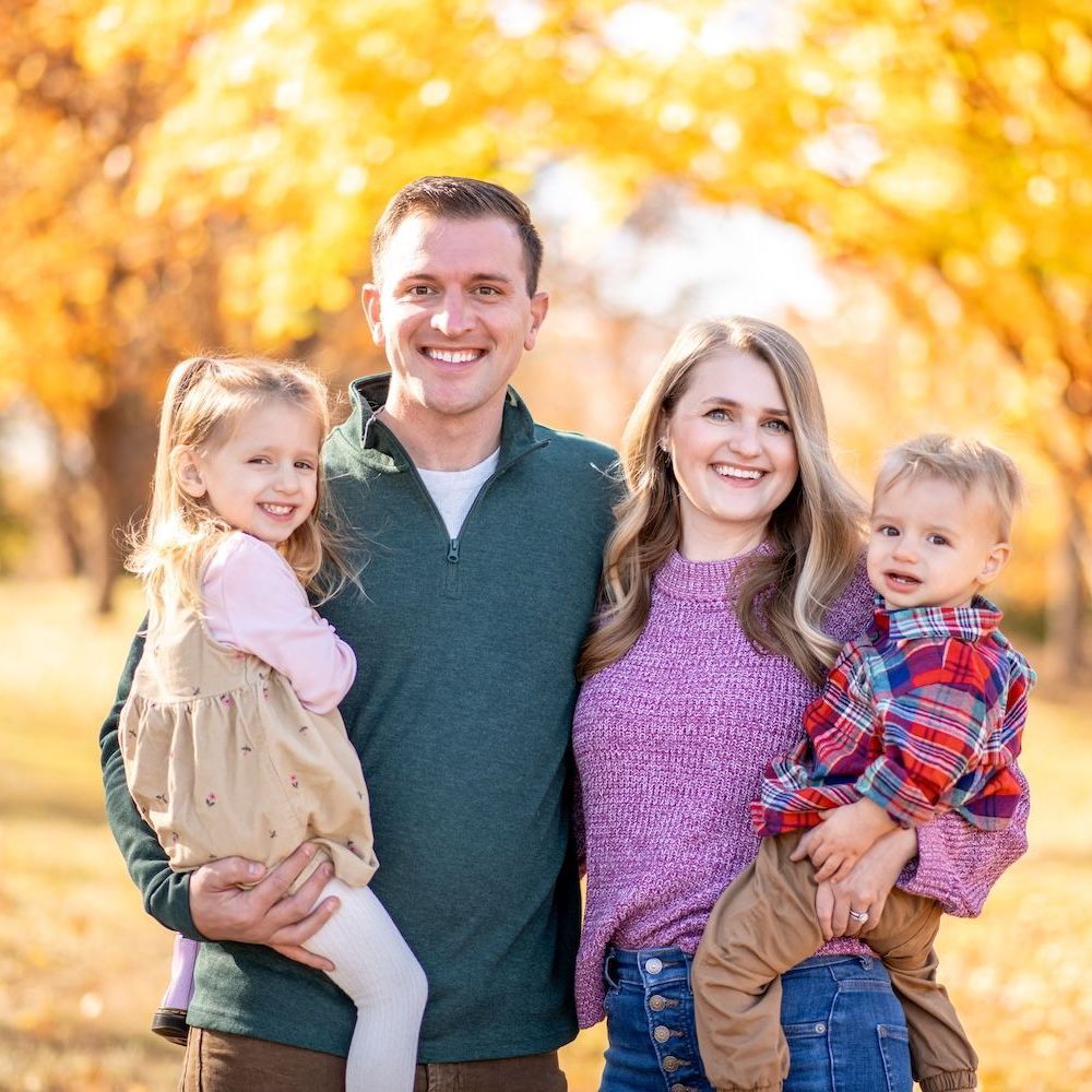 A man and woman are holding a baby and a little girl.