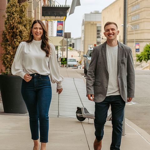 A man and a woman are walking down a sidewalk