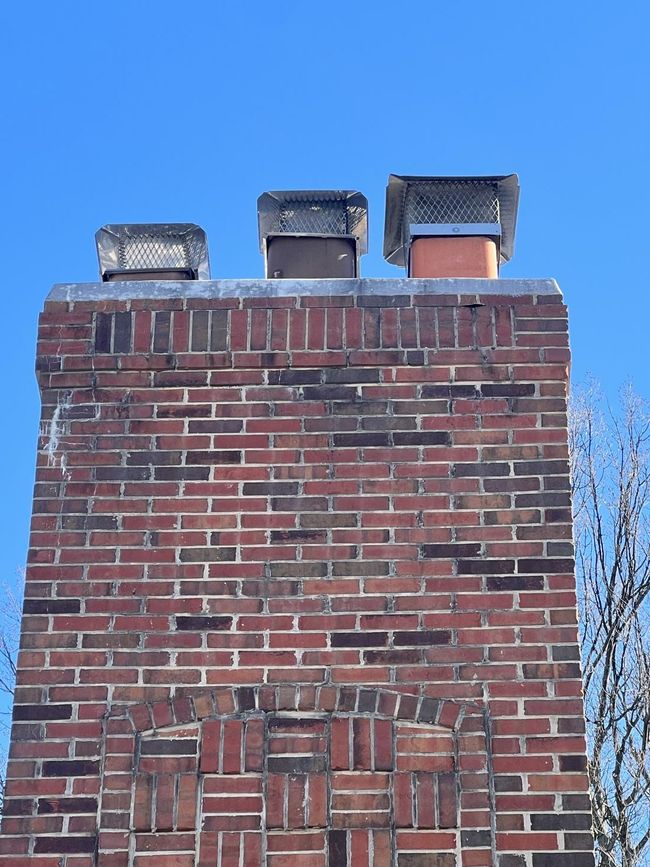 A brick chimney with a blue sky in the background