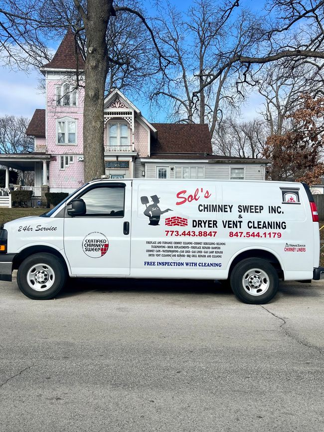 A white van is parked in front of a pink house.