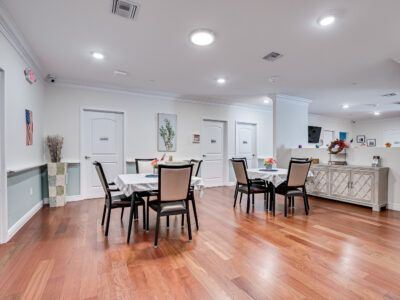 A large room with hardwood floors and tables and chairs.