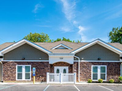 A large brick house with a parking lot in front of it.
