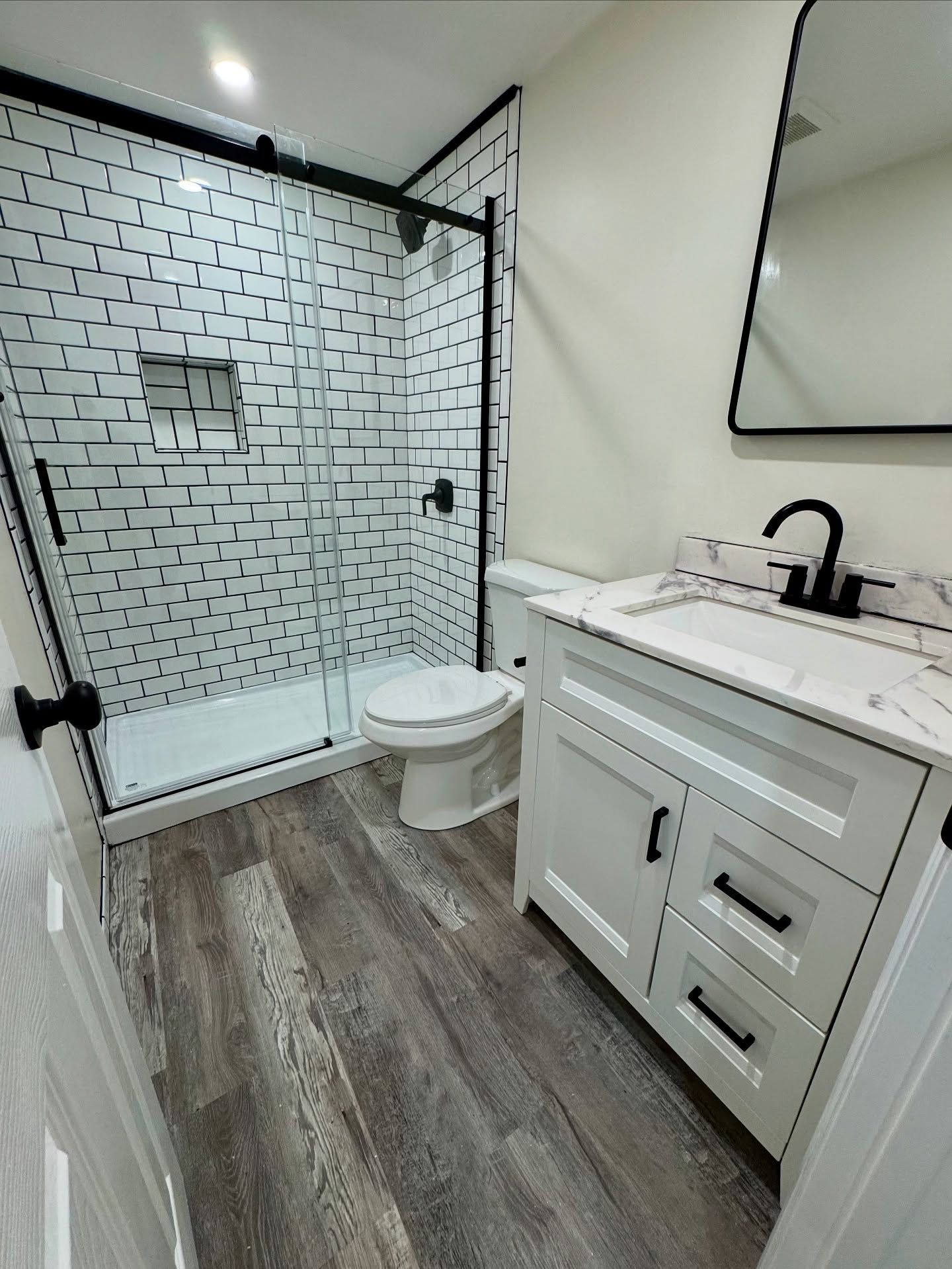 Clean modern bathroom renovation with tile shower and custom vanity. Precision installation and clean finish details