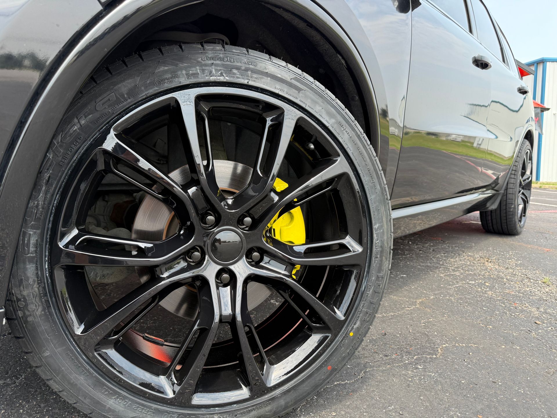 A close up of a black car with yellow brake calipers.