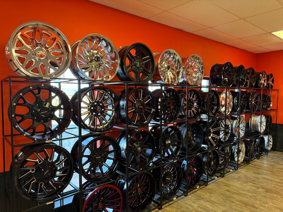 A bunch of wheels are stacked on top of each other in a store.