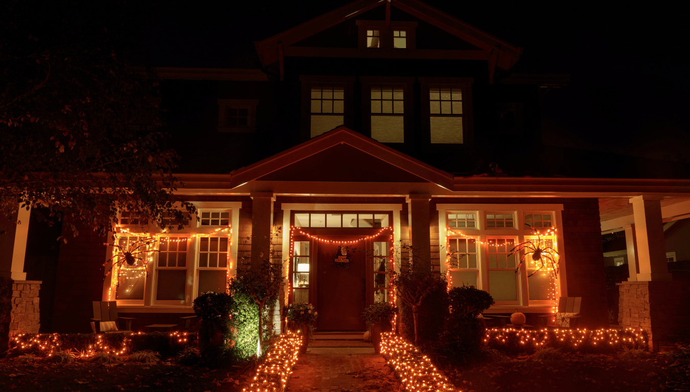 a house is decorated for halloween with lots of orange lights .