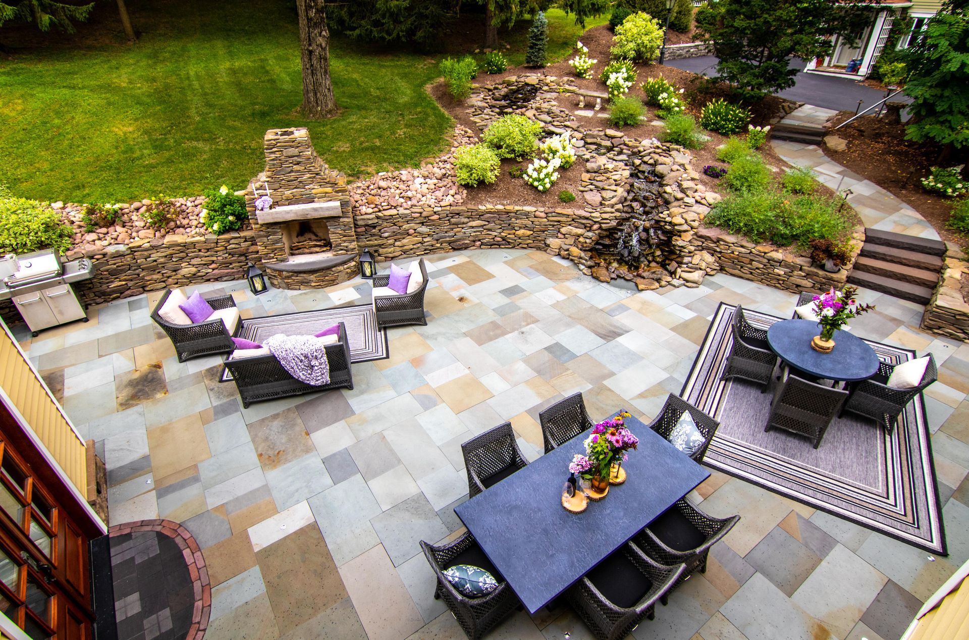 Flagstone paver patio with natural stone fireplace and retaining wall
