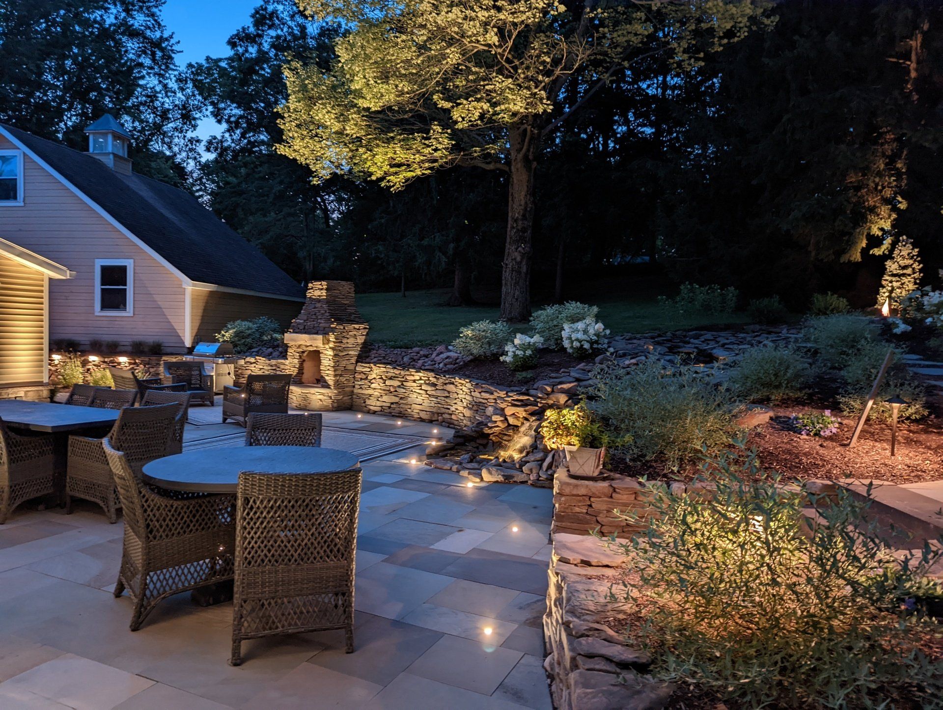 a patio with a table and chairs is lit up at night