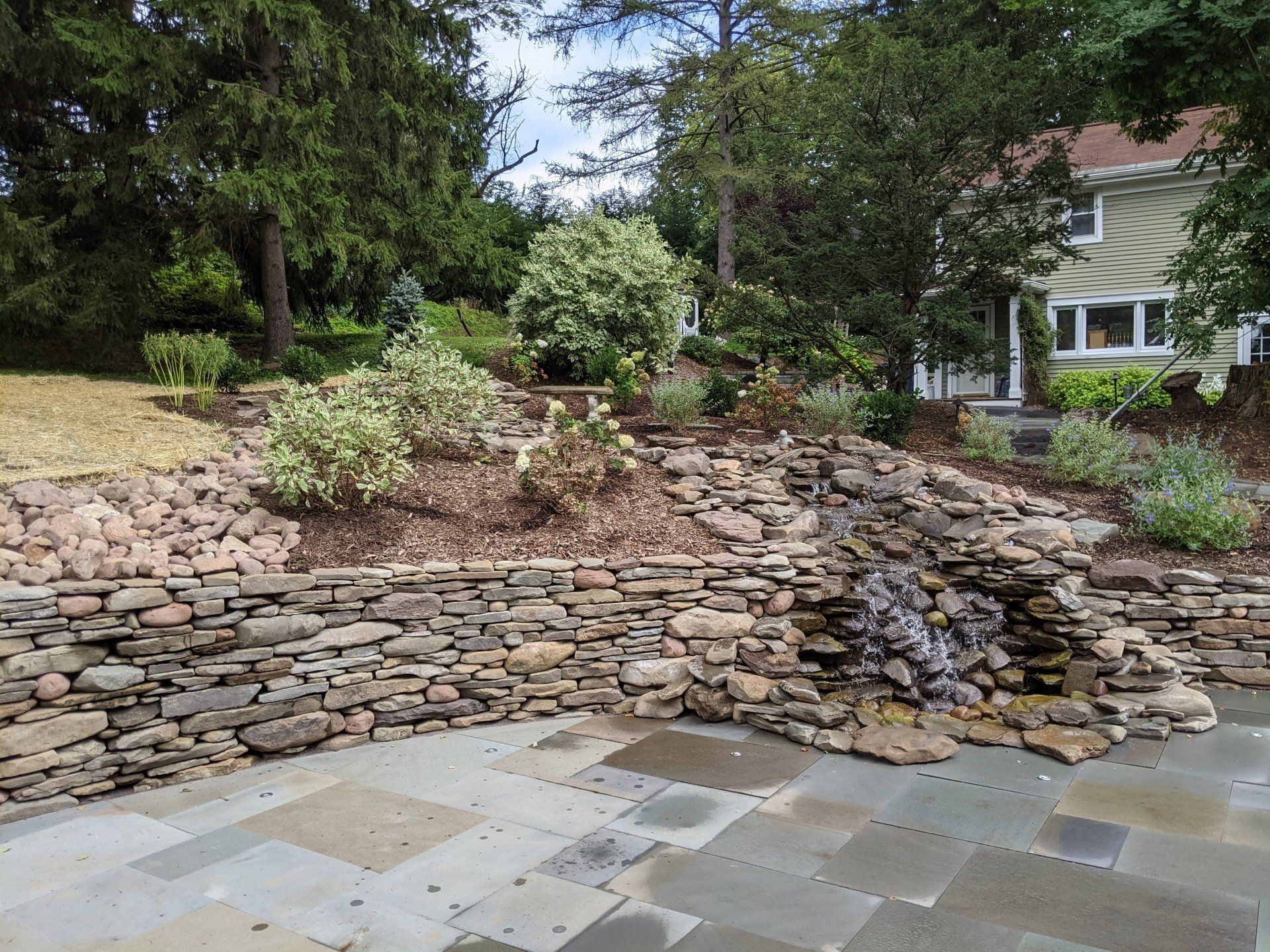 Natural stone retaining wall and water feature by Hunter Springs Landscape Artisans