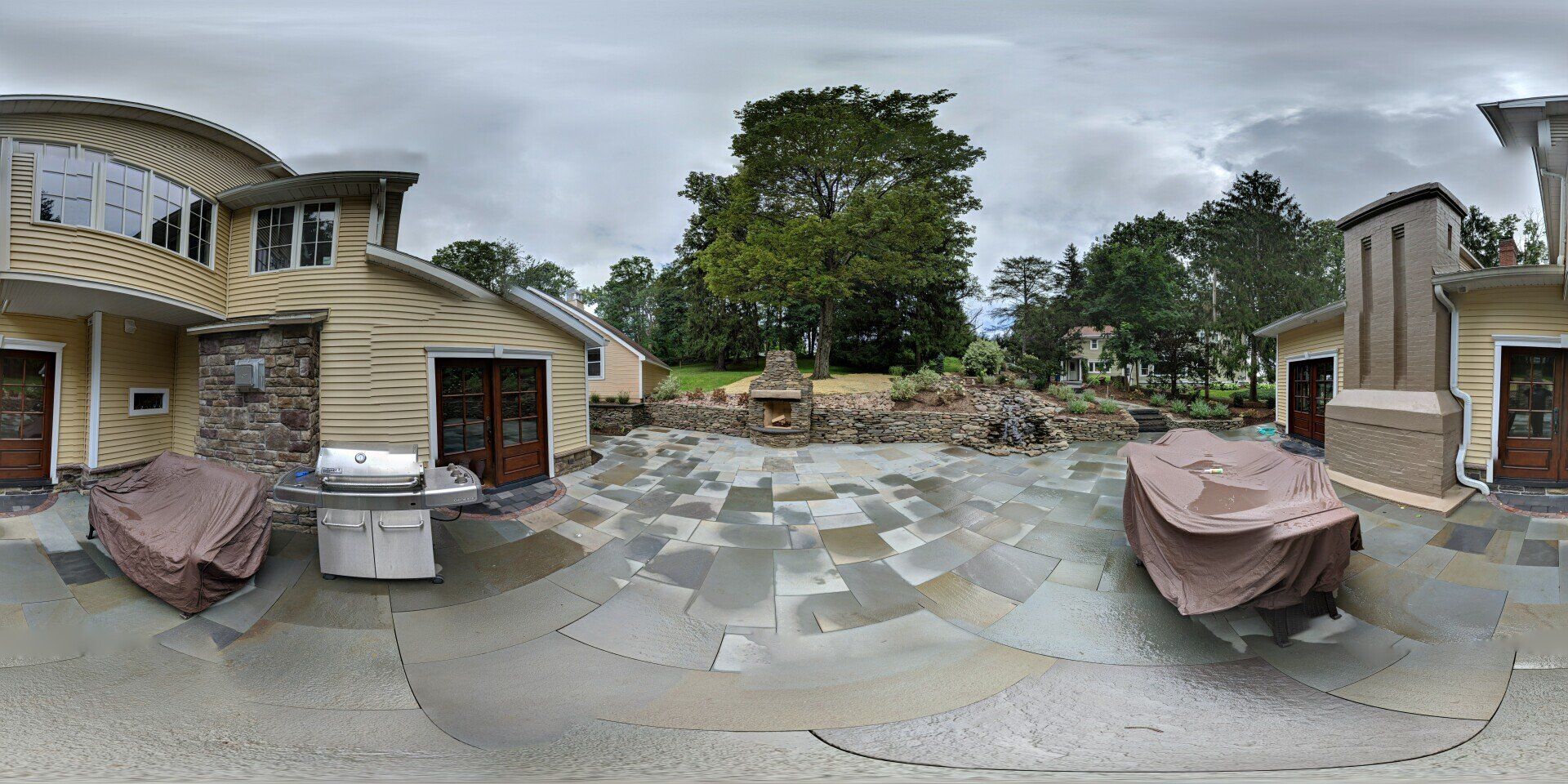a 360 degree view of a house with a patio and a grill .