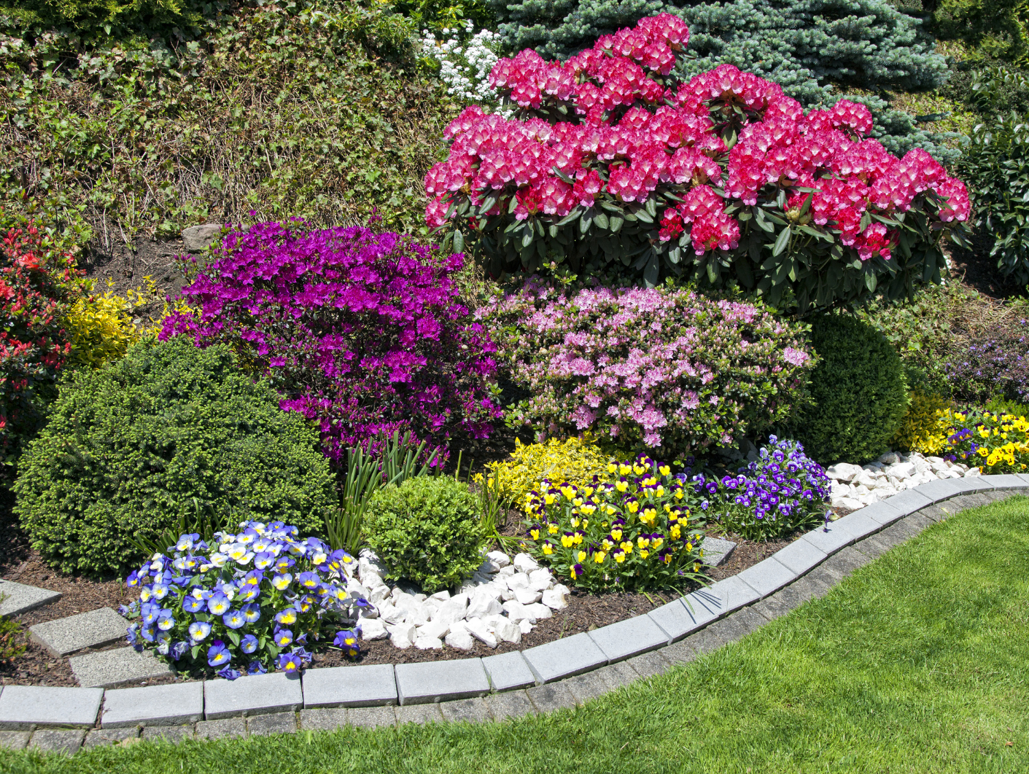 Garden Design with beautiful, colorful flowers and stone edging