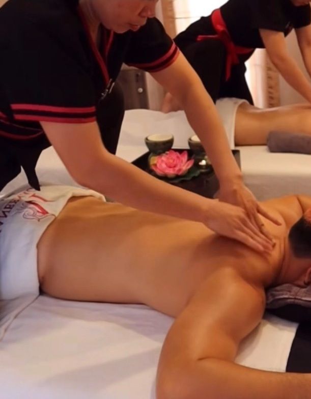 Wooden stool with candles, brush, and flower; spa setting.