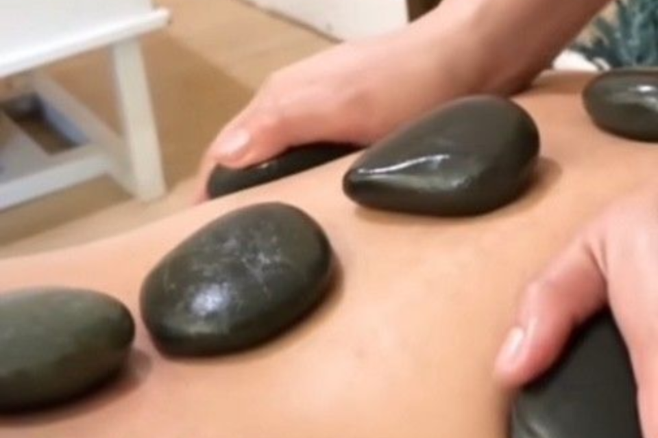 Woman receiving a facial treatment. Black mask is being applied with a brush in a spa setting.