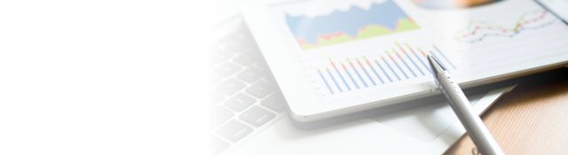 A pen is sitting on top of a notebook next to a graph.
