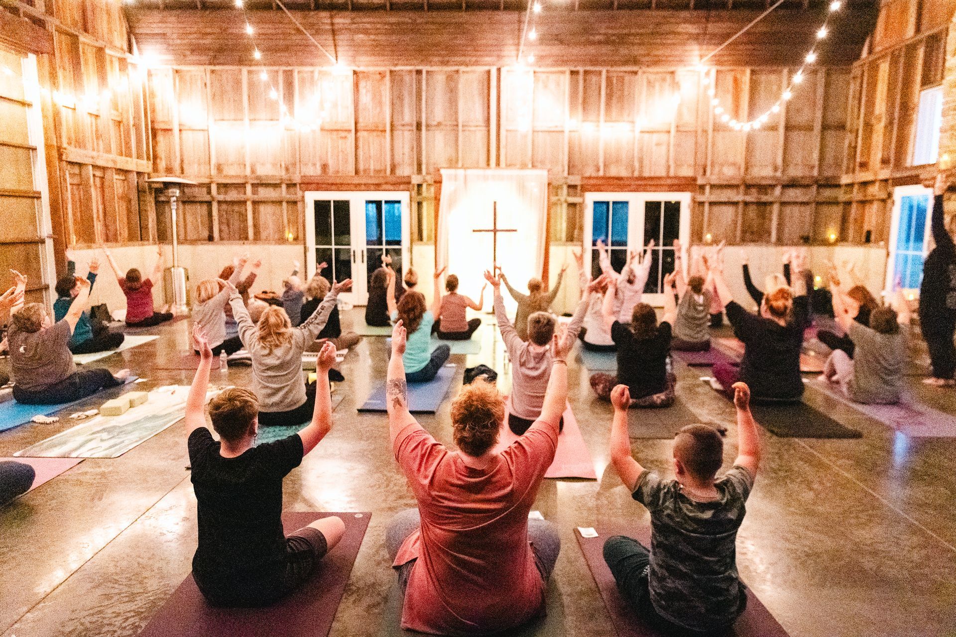 Large group of yoga students seated on mats, preparing for a guided meditation session