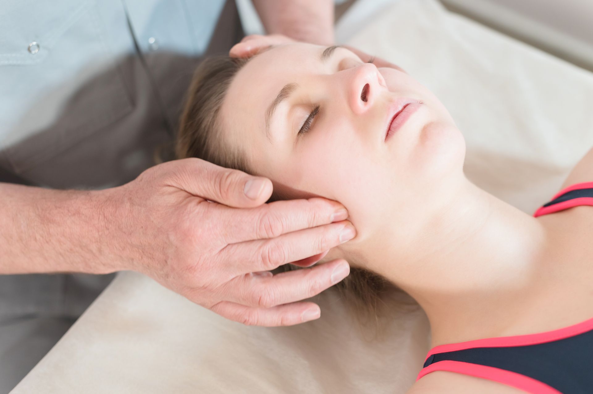 A woman is getting a head massage from a man.