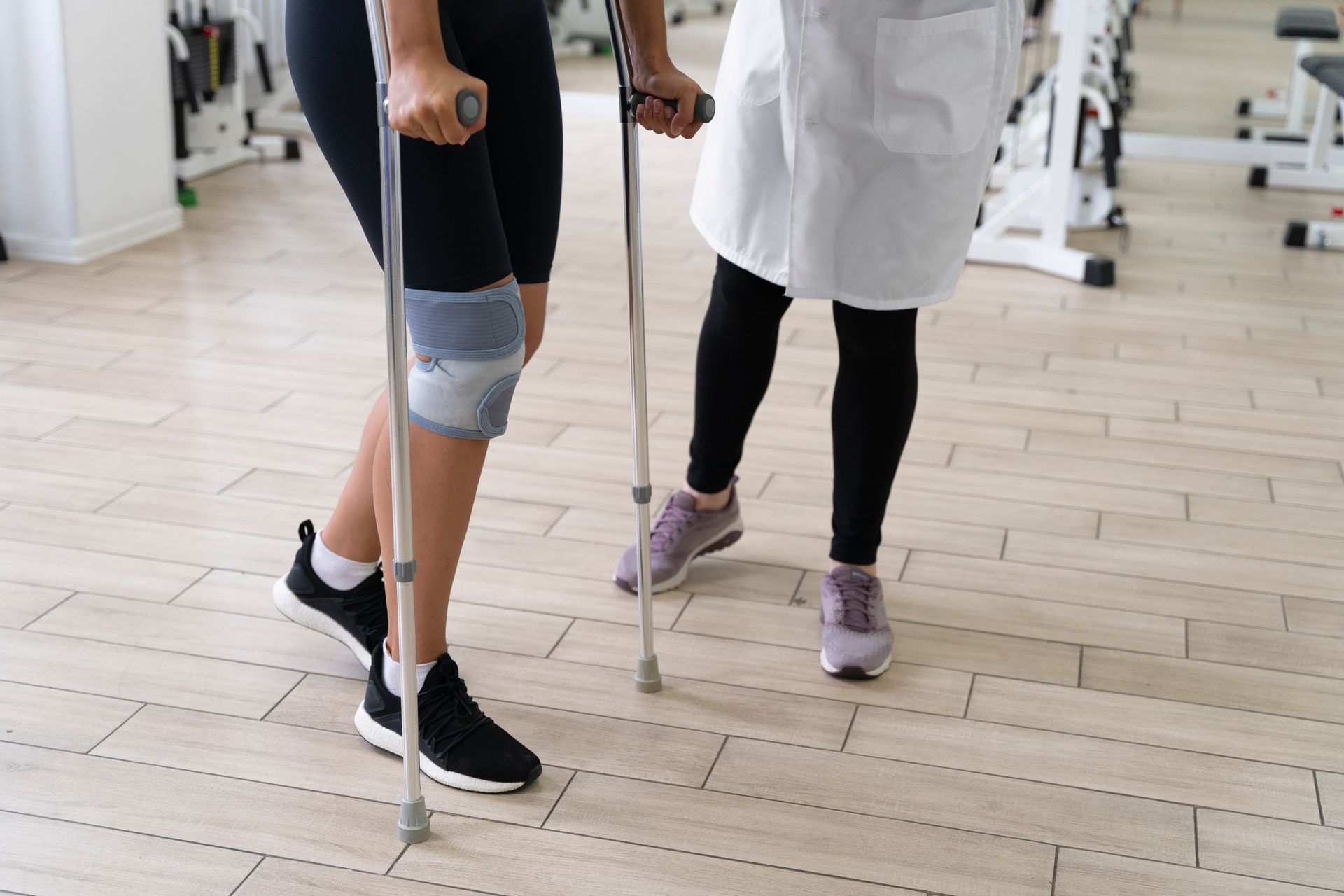 a woman with crutches is being helped by a doctor in a gym .