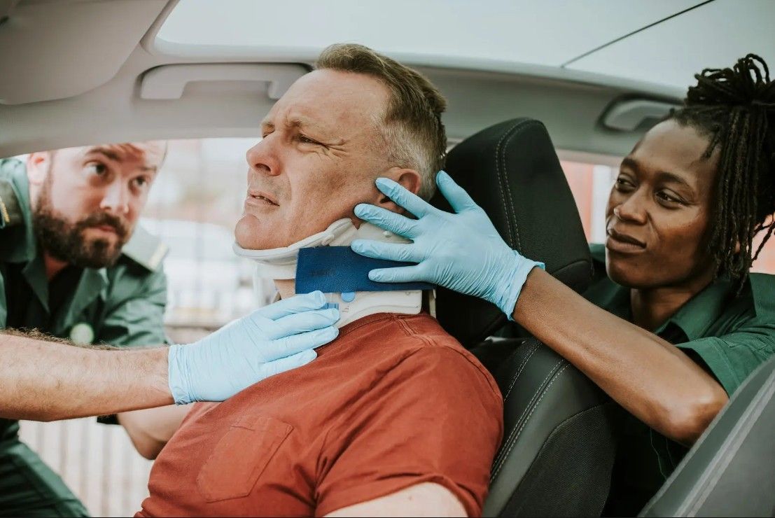 A man with a neck brace is sitting in a car.