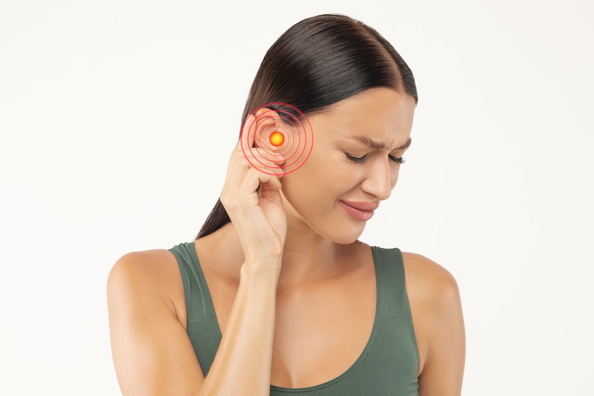 A woman is holding her ear in pain.