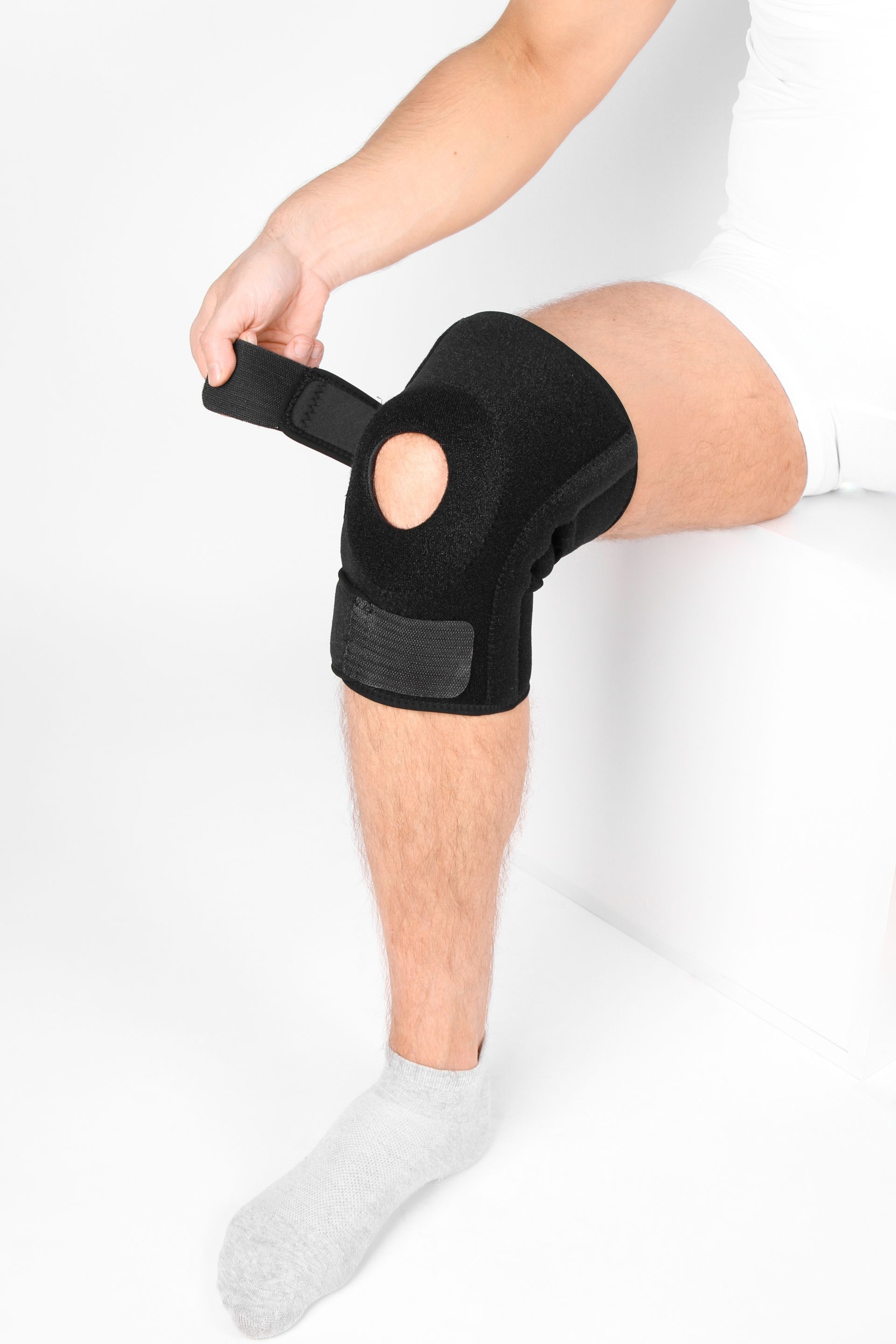 A person is wearing a black knee brace on their knee.