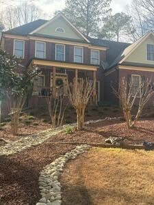 Person gardening in a flower bed filled with pink and purple flowers.