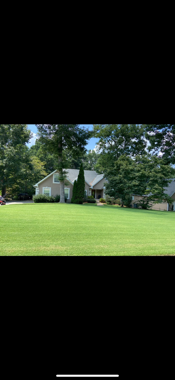 Power washer cleaning a weathered wooden fence.