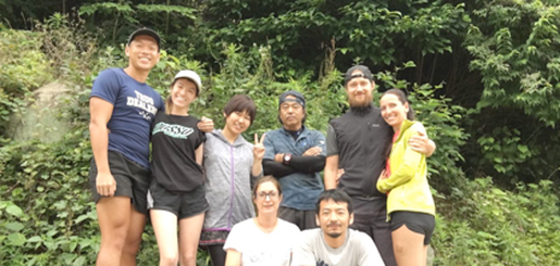 A group of people are posing for a picture in the woods.