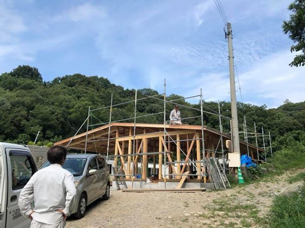 A man is standing in front of a building under construction.