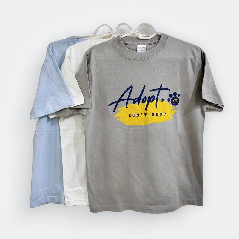 A group of adopt t-shirts are hanging on a hanger