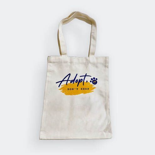 A white tote bag with the words adopt on it