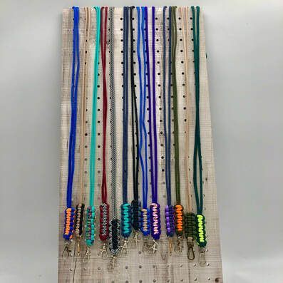 A bunch of lanyards are sitting on top of a wooden board.