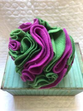 A green and purple flower is sitting on top of a blue box.