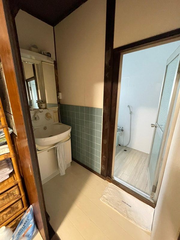 A bathroom with a sink , mirror , and shower.