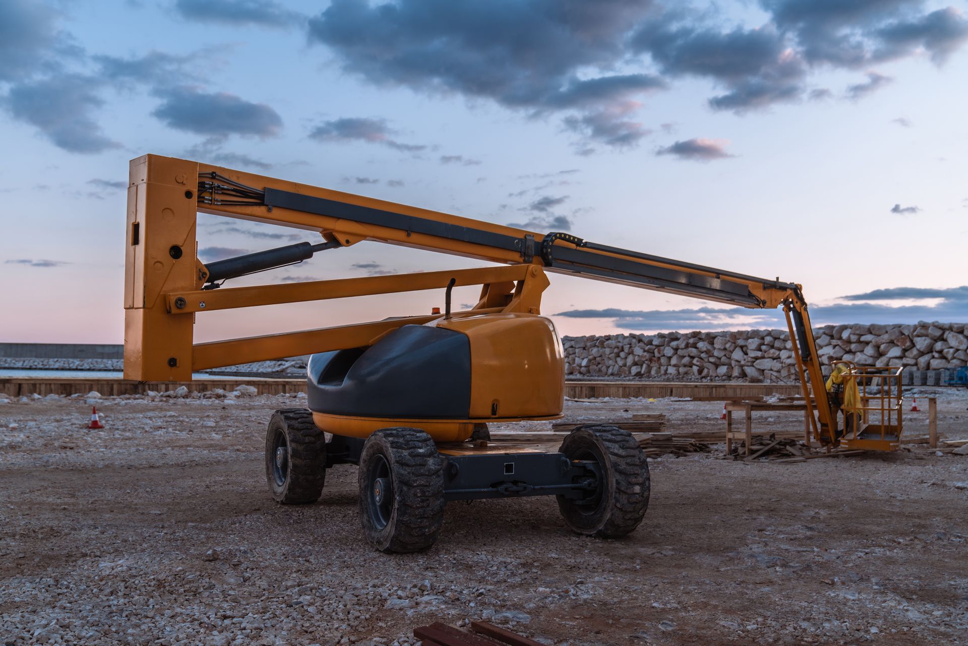 A yellow construction vehicle is parked on a gravel road.