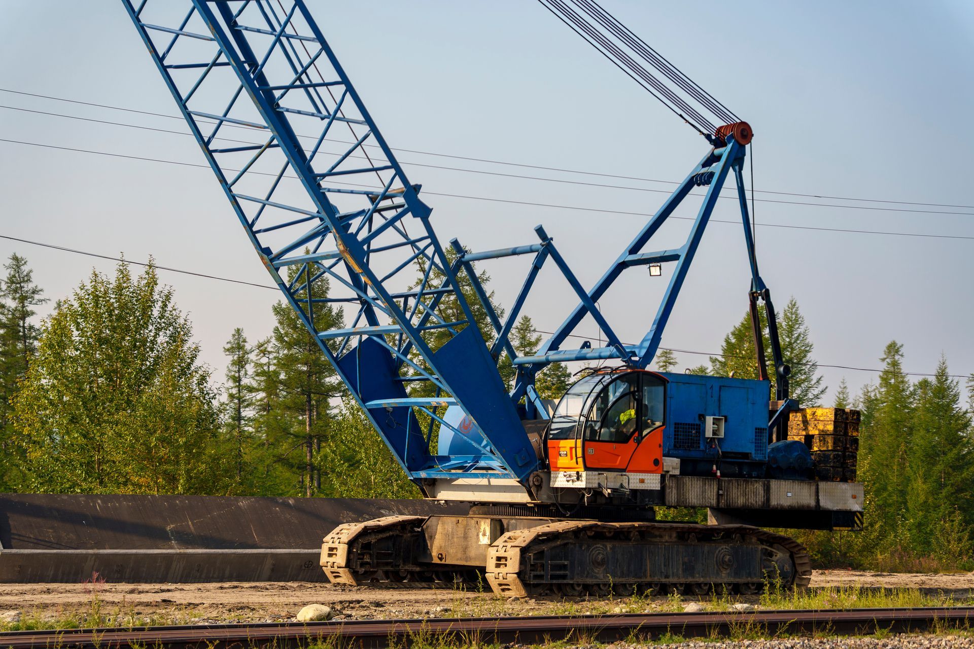 A large crane is sitting on top of a train track.