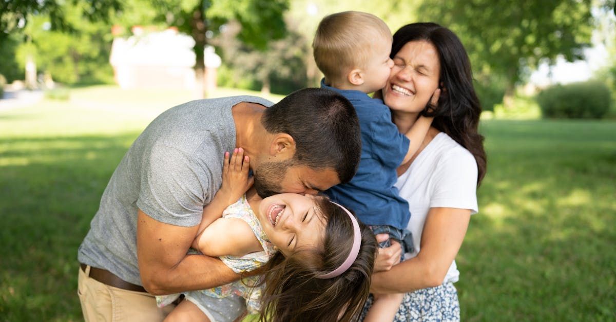 Image of parents hugging and kissing their two children