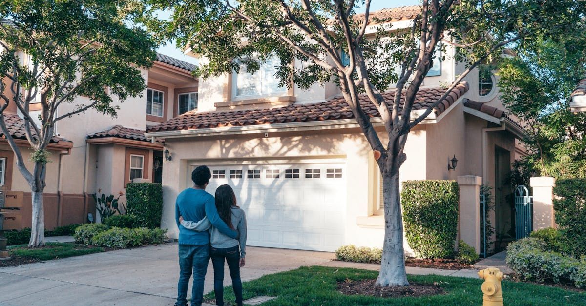 Image of a couple hugging in front of the home they just purchased