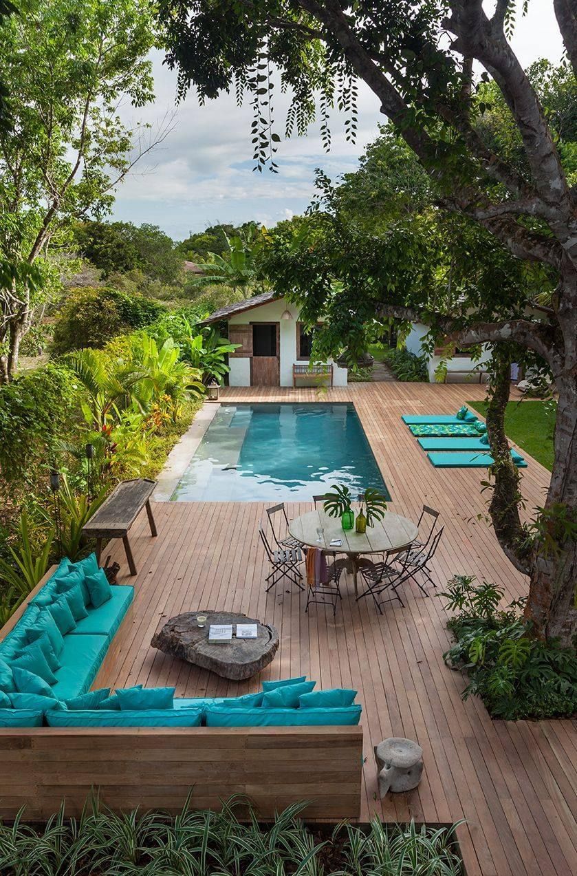 There is a large swimming pool in the backyard with a wooden deck.