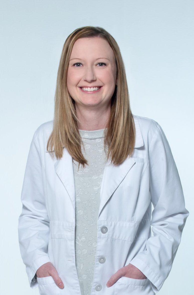 a woman in a white lab coat is smiling for the camera