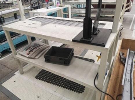 Un estante blanco con una caja negra encima en una fábrica.