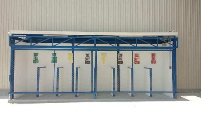 Un refugio azul con una pared blanca detrás.