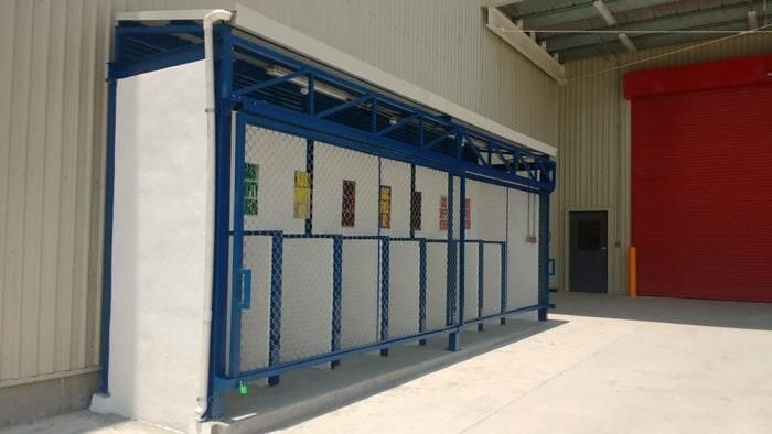 Un edificio azul y blanco con una puerta roja al fondo.