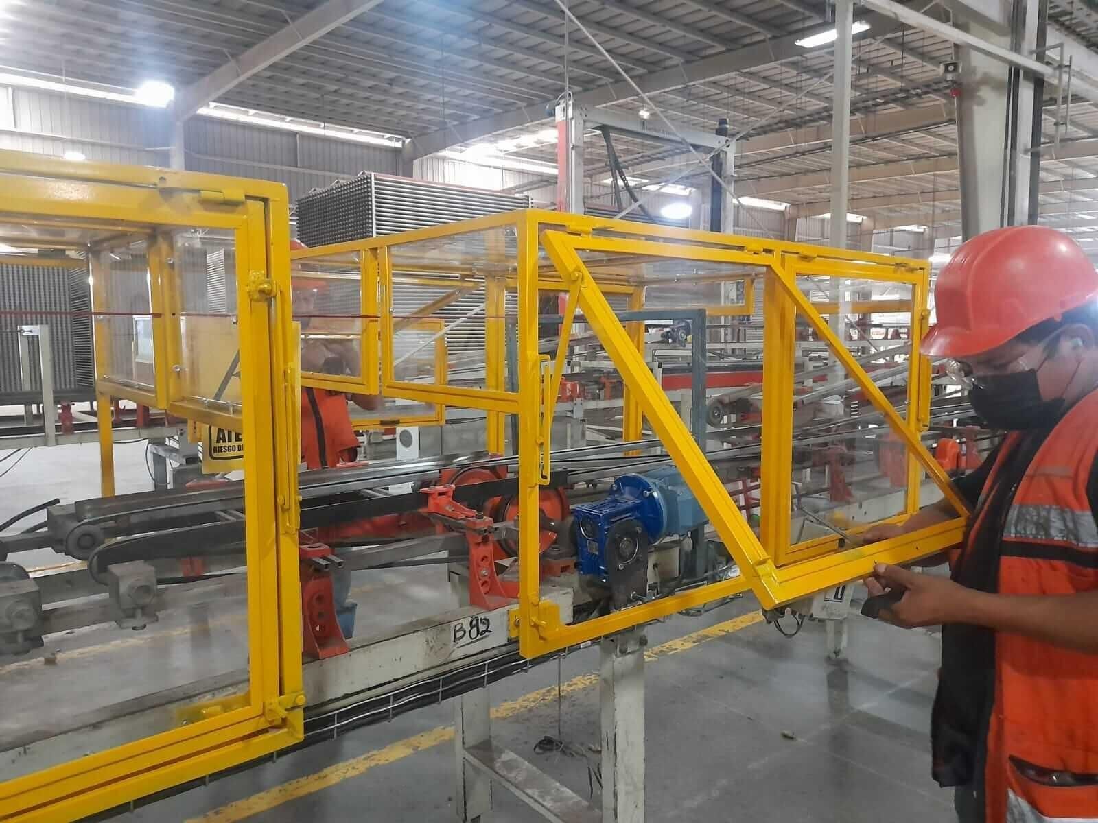 Un hombre que lleva un casco está trabajando en una máquina en una fábrica.