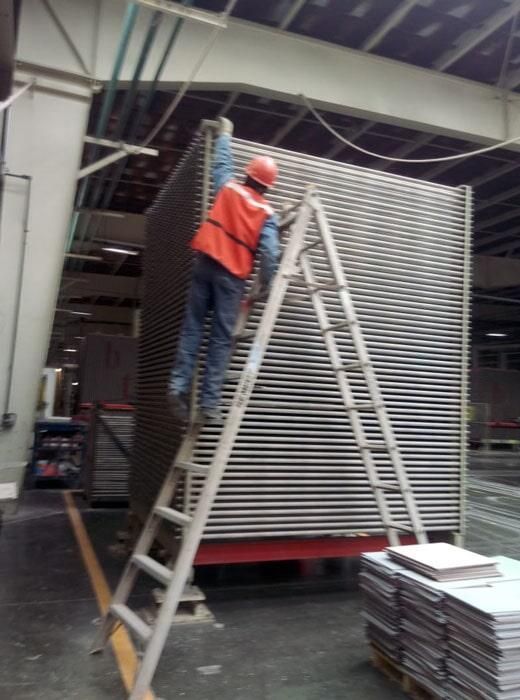 Un hombre de pie en una escalera delante de una pila de andamios.