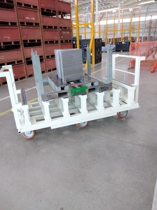 Un carrito blanco con ruedas está en un almacén.